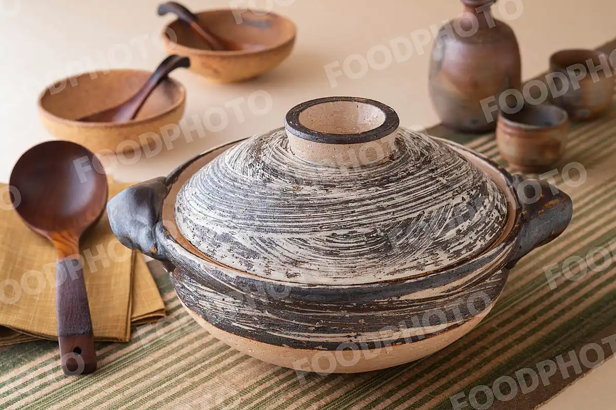 木製のおたまと荒々しい模様の大きな土鍋