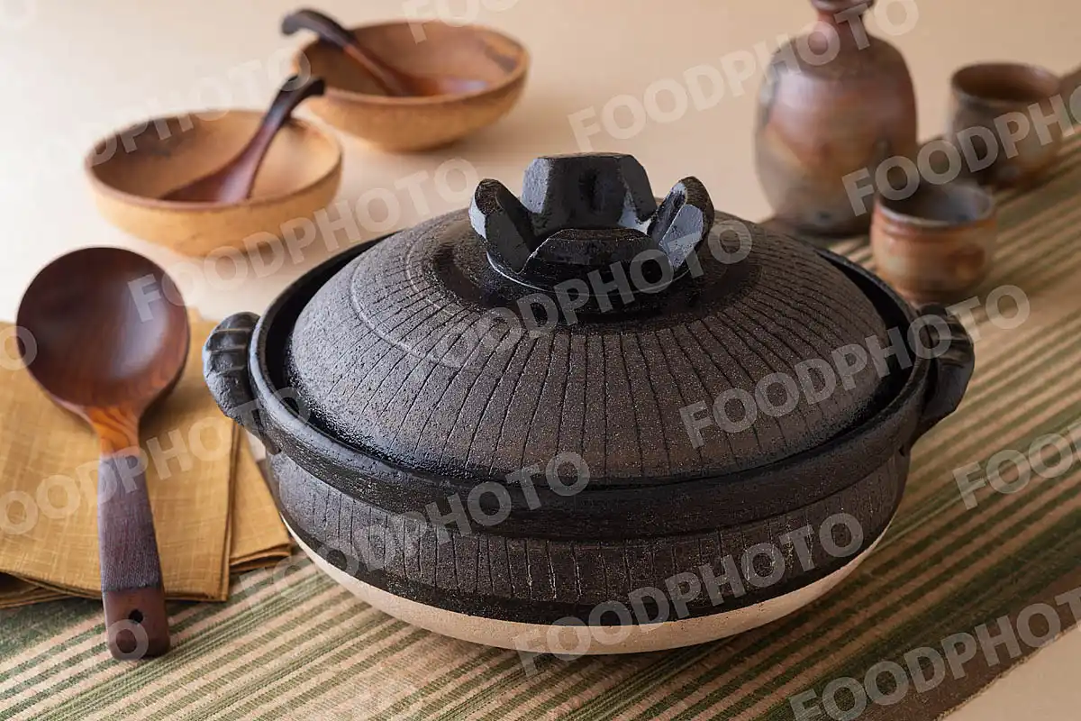 木製のおたまとずっしりと力強い大きな黒い土鍋