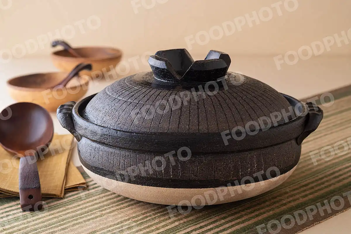 木製のおたまとずっしりと力強い大きな黒い土鍋