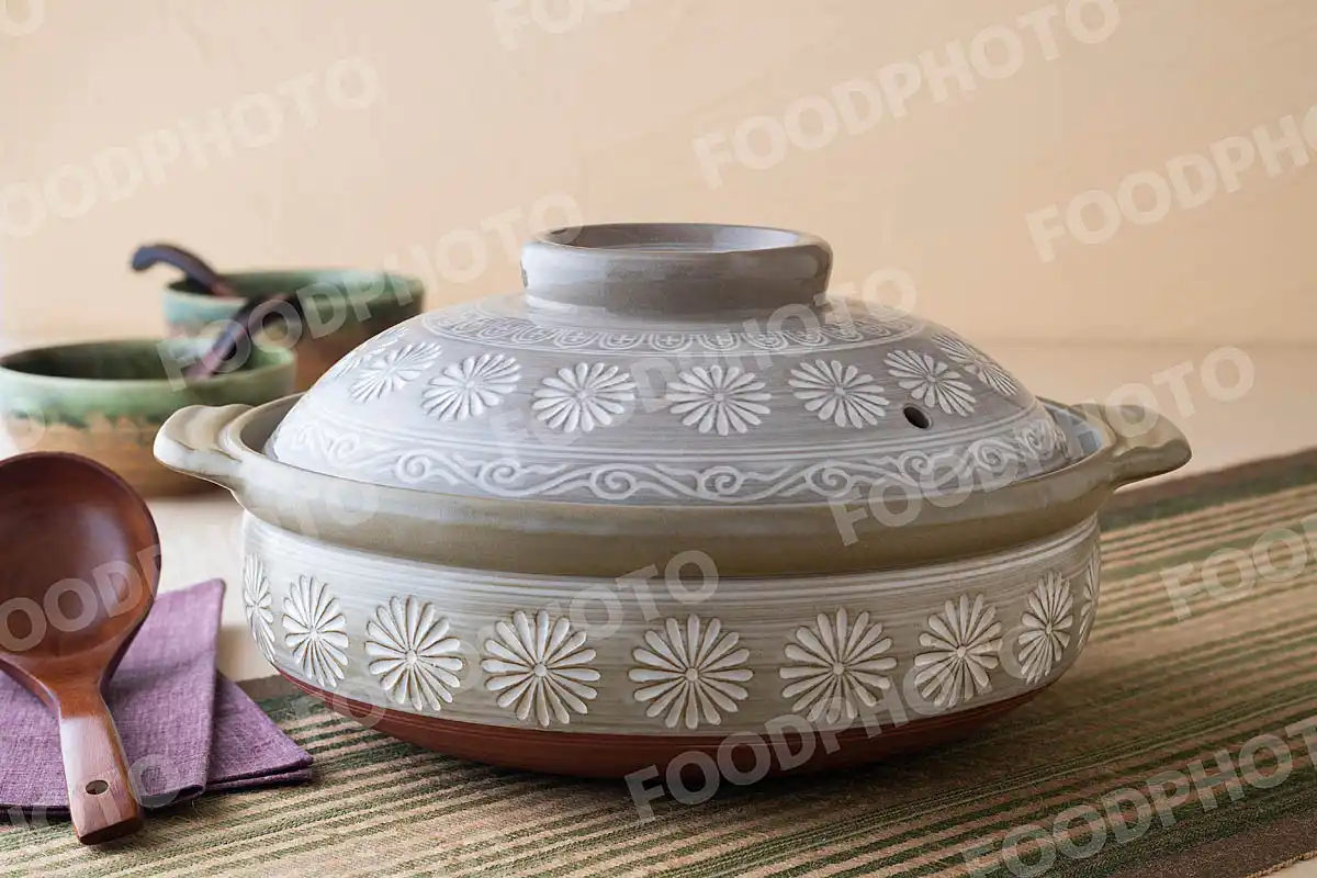 木製のおたまと菊花の文様が特徴的な大きな土鍋