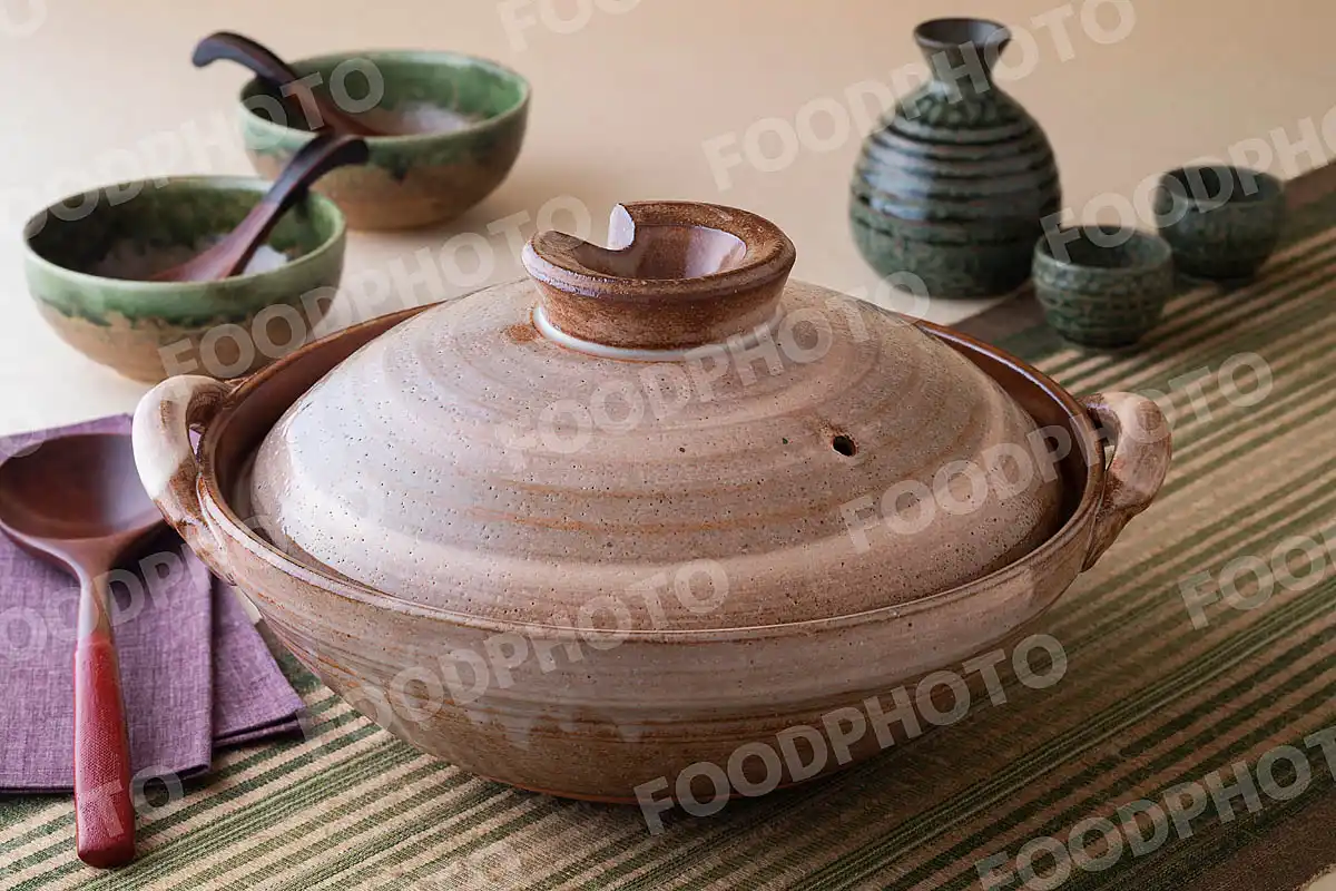 木製のおたまと渦巻き文様の大きな土鍋