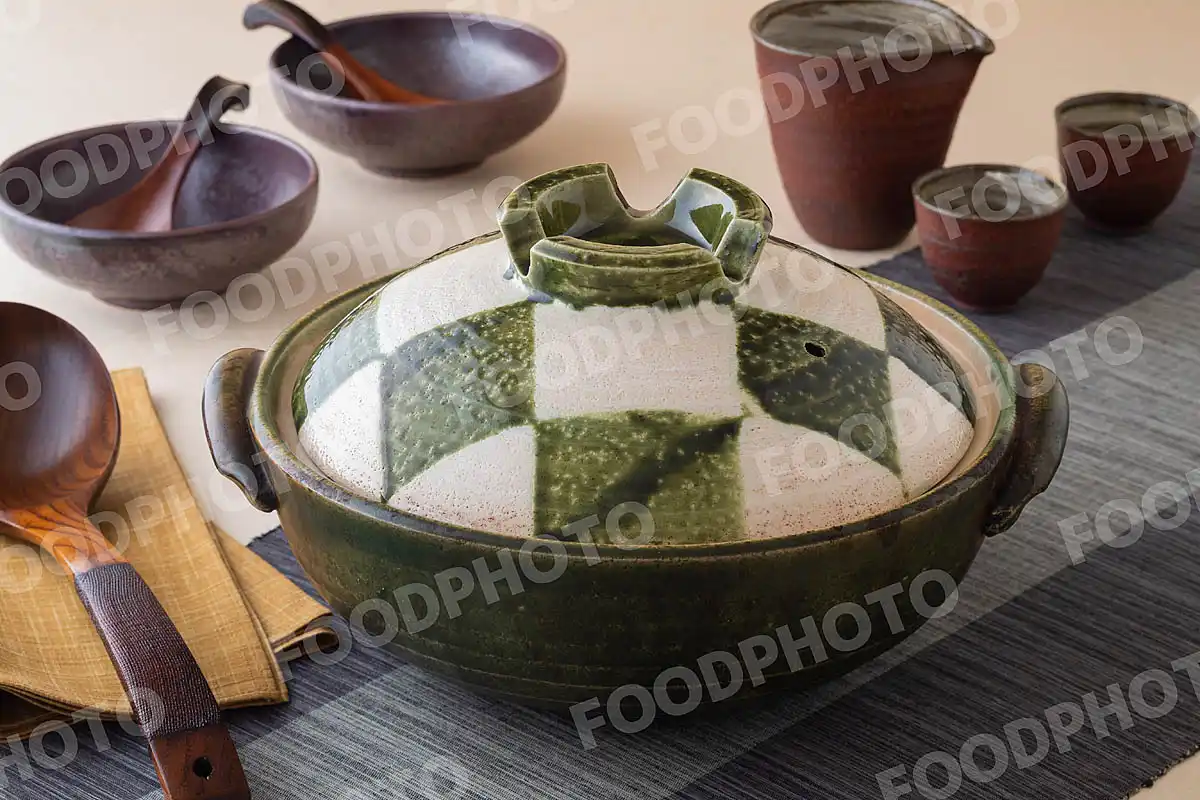 木製のおたまと白と深緑の市松模様がきれいな土鍋