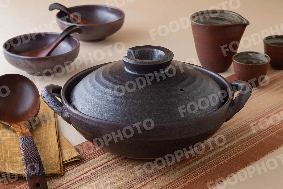 木製のおたまと鋼のような力強い風合いの土鍋