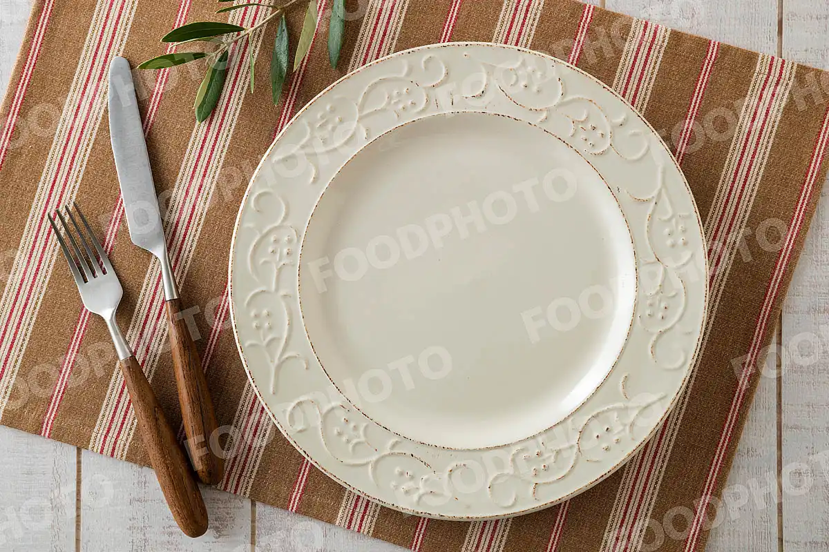 カトラリーとリムにつた模様の入ったラウンドディナープレート