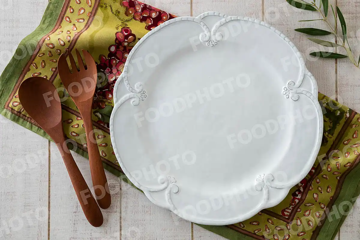 木製カトラリーとエレガントなレリーフのディナープレート