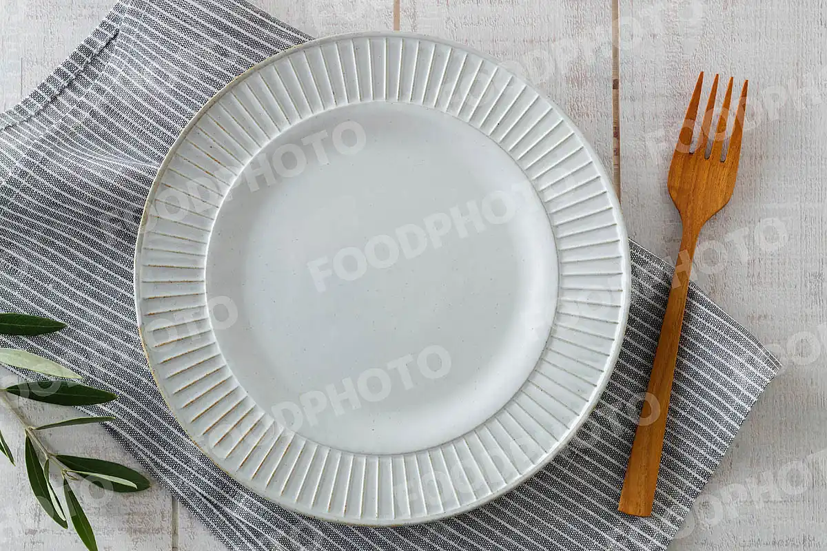 木製フォークとカジュアルなディナープレート
