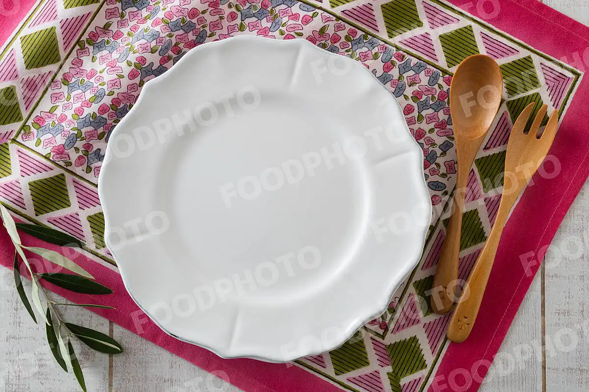 木製カトラリーと花型リムデザインのディナープレート