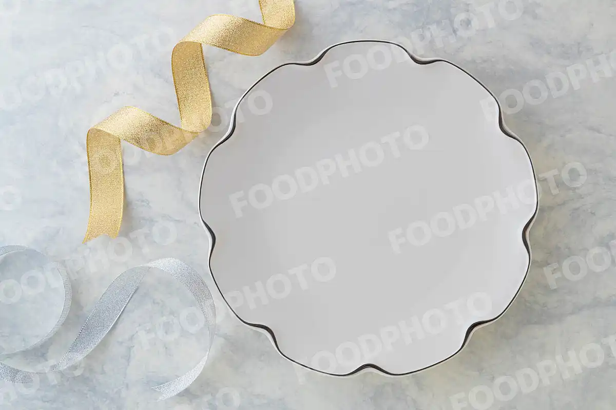 金銀のリボンと銀縁の白いラウンドディナープレート