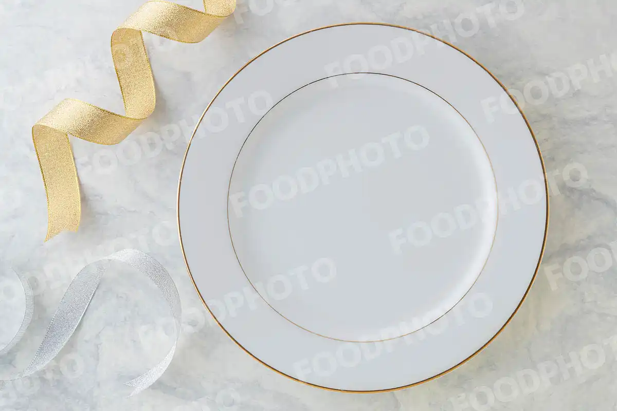 金銀のリボンと金縁の白いラウンドディナープレート