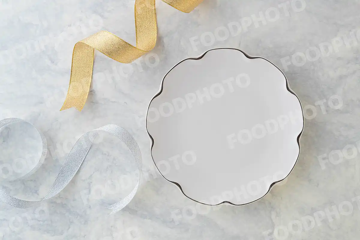 金銀のリボンと金縁の白いラウンドデザートプレート