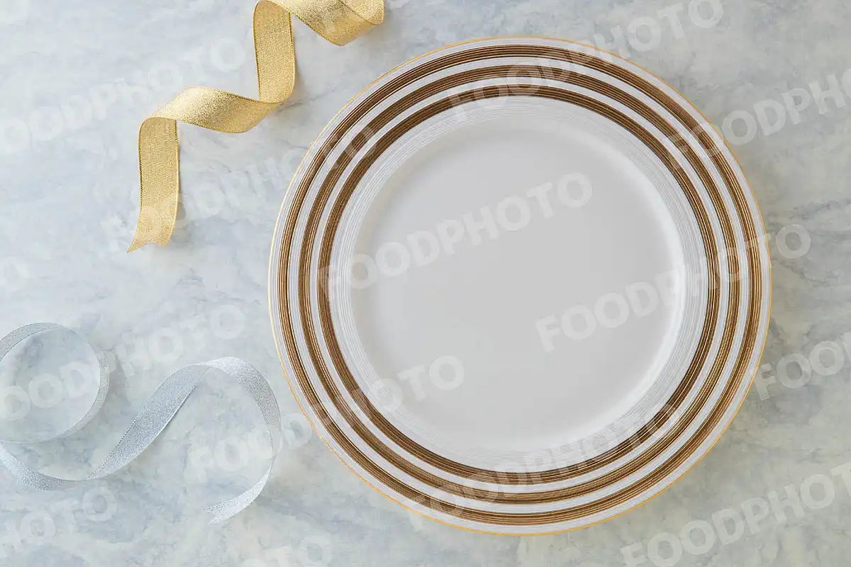 金銀のリボンと金ラインの入った白いラウンドディナープレート