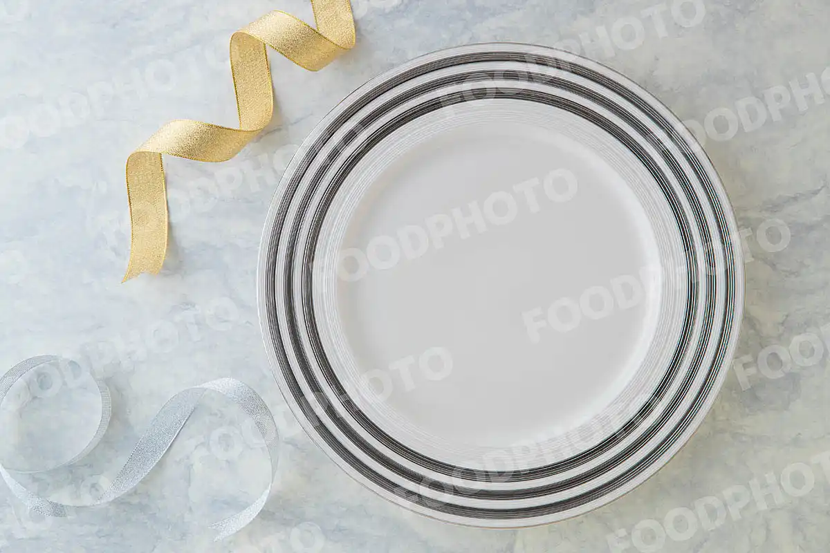 金銀のリボンと銀ラインの入った白いラウンドディナープレート