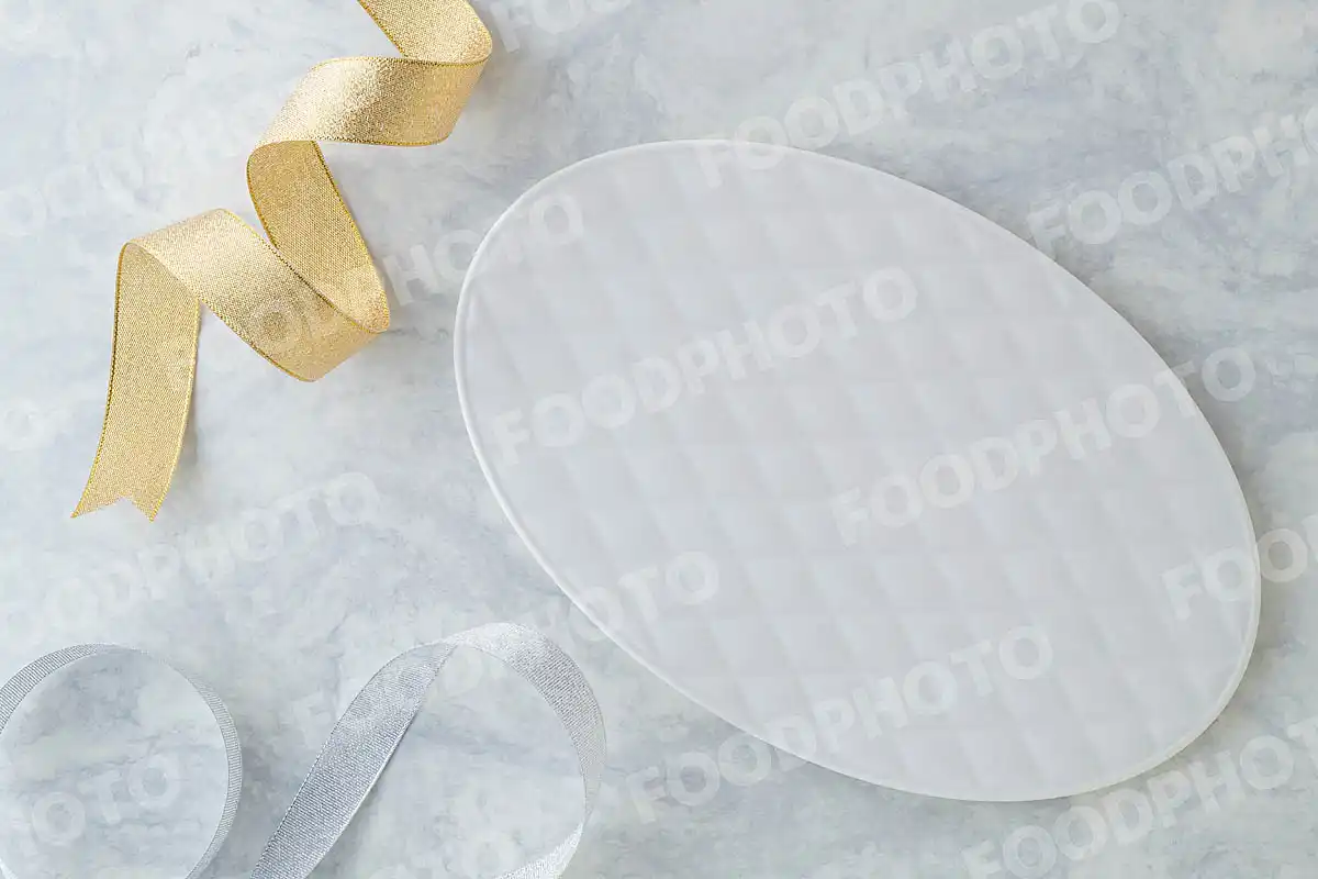 金銀のリボンと柔らかみある表情の白いオーバルデザートプレート。