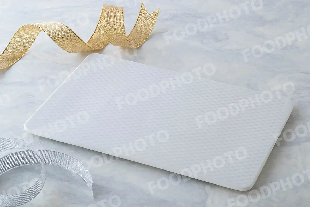 金銀のリボンと網目模様の白いスクエアデザートプレート。