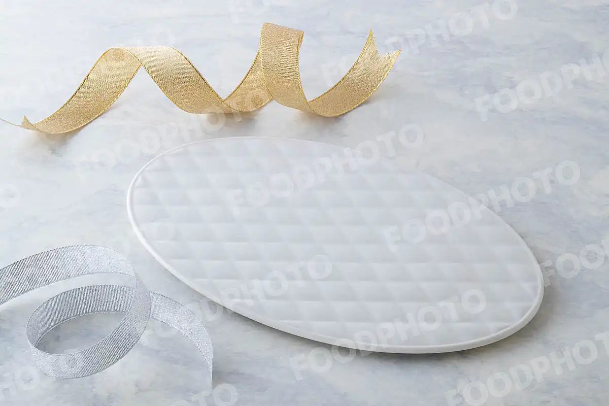 金銀のリボンと柔らかみある表情の白いオーバルデザートプレート。