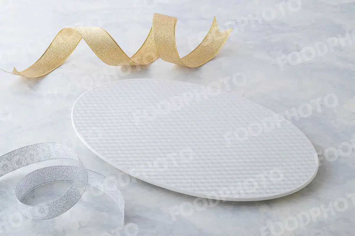 金銀のリボンと網目模様の白いオーバルデザートプレート。