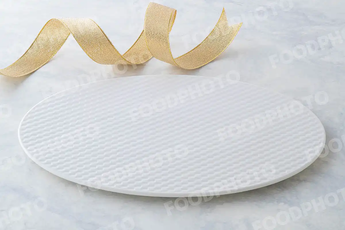 金銀のリボンと網目模様の白いオーバルデザートプレート。