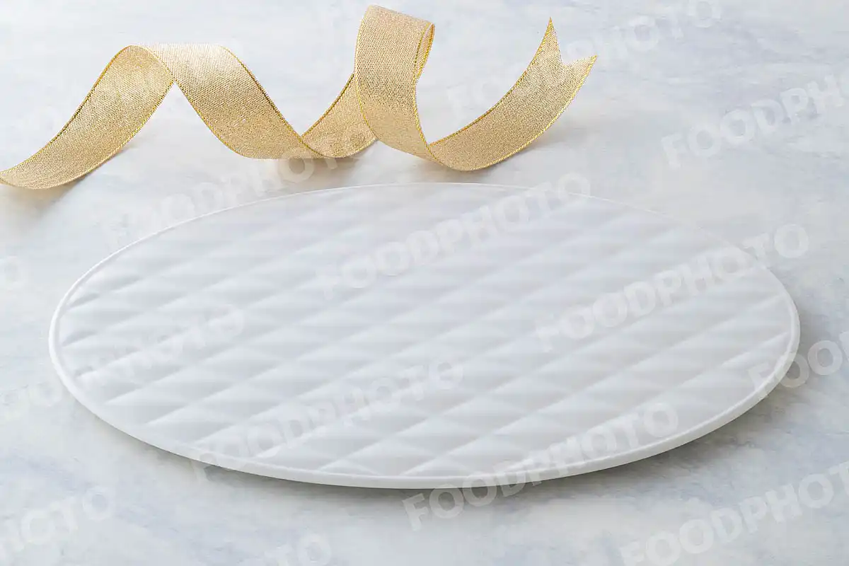 金銀のリボンと柔らかみある表情の白いオーバルデザートプレート。