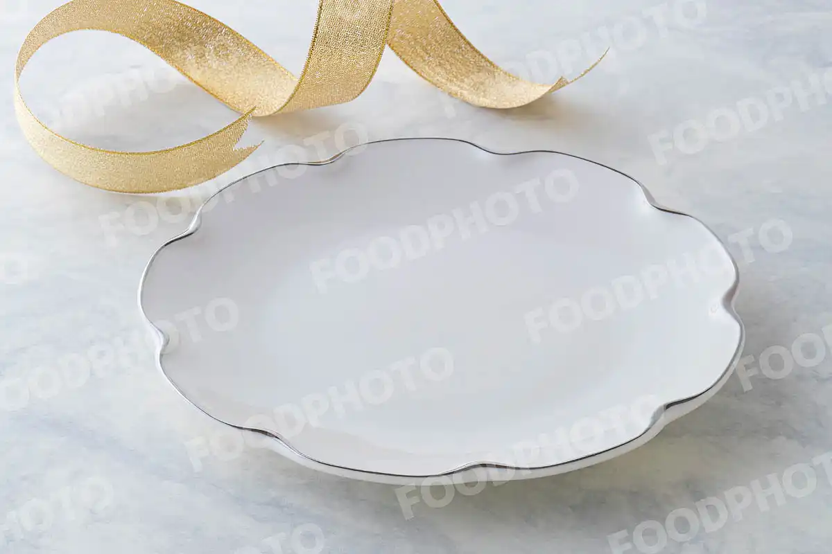 金銀のリボンと銀縁の白いラウンドディナープレート