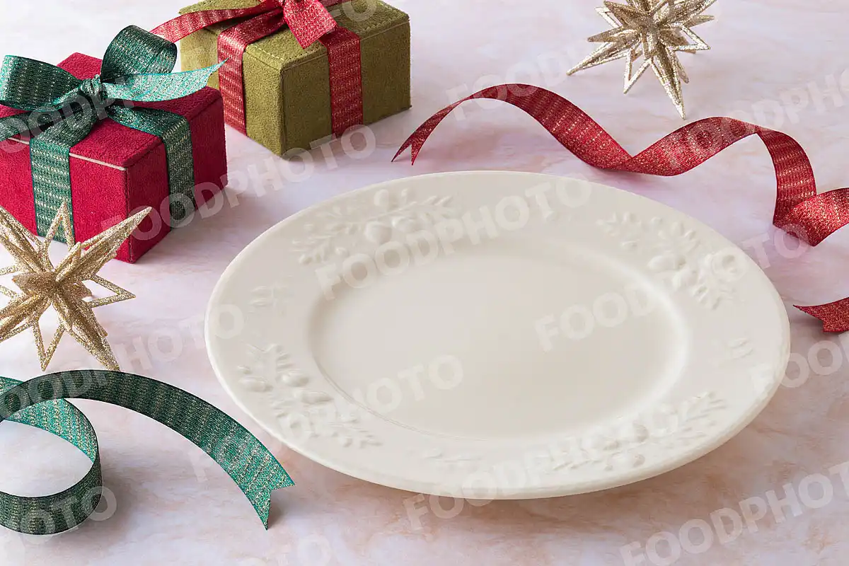 赤緑のリボンとリムに木ノ実を施したクリーム色のラウンドディナープレート