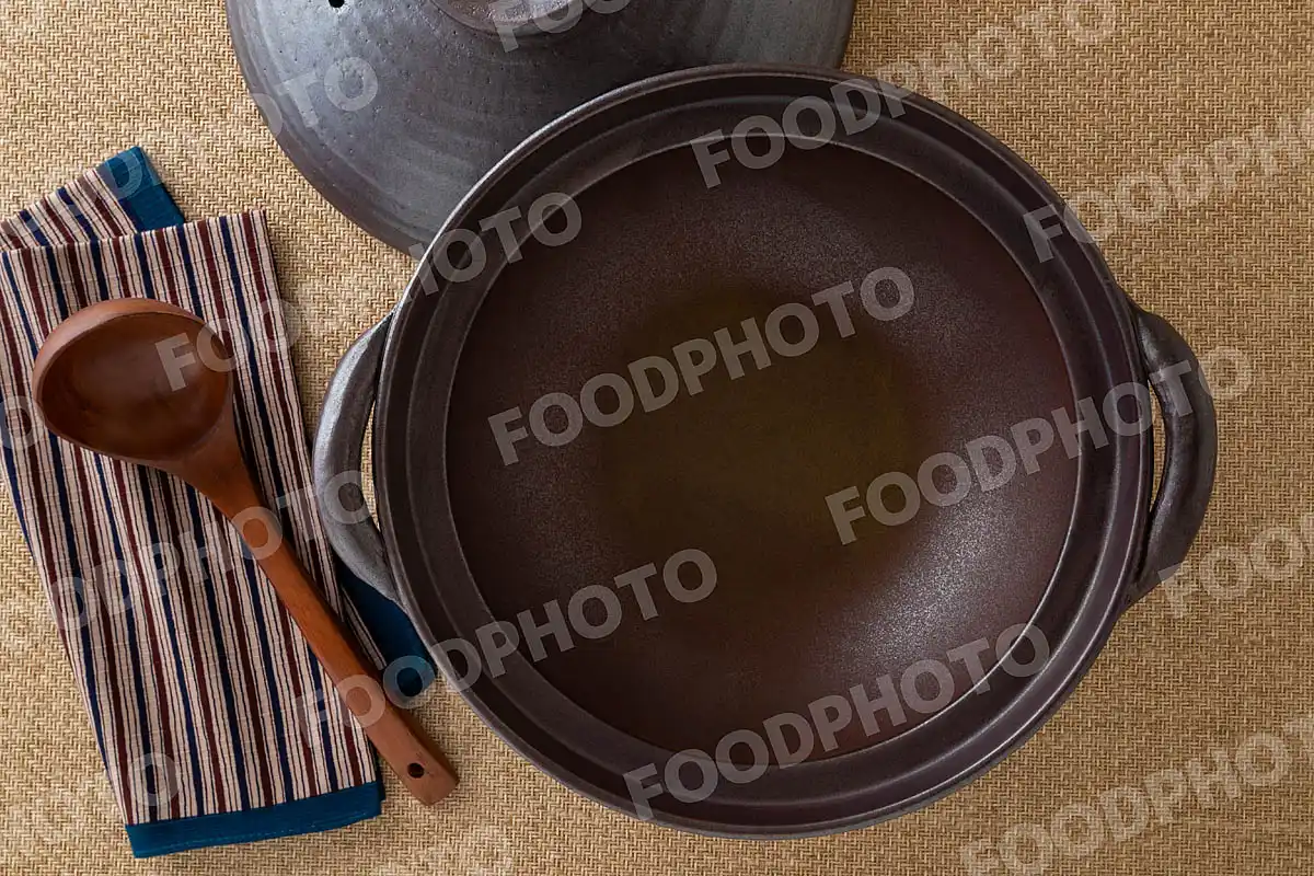 木製のおたまと鋼のような力強い風合いの大きな土鍋 / 蓋開