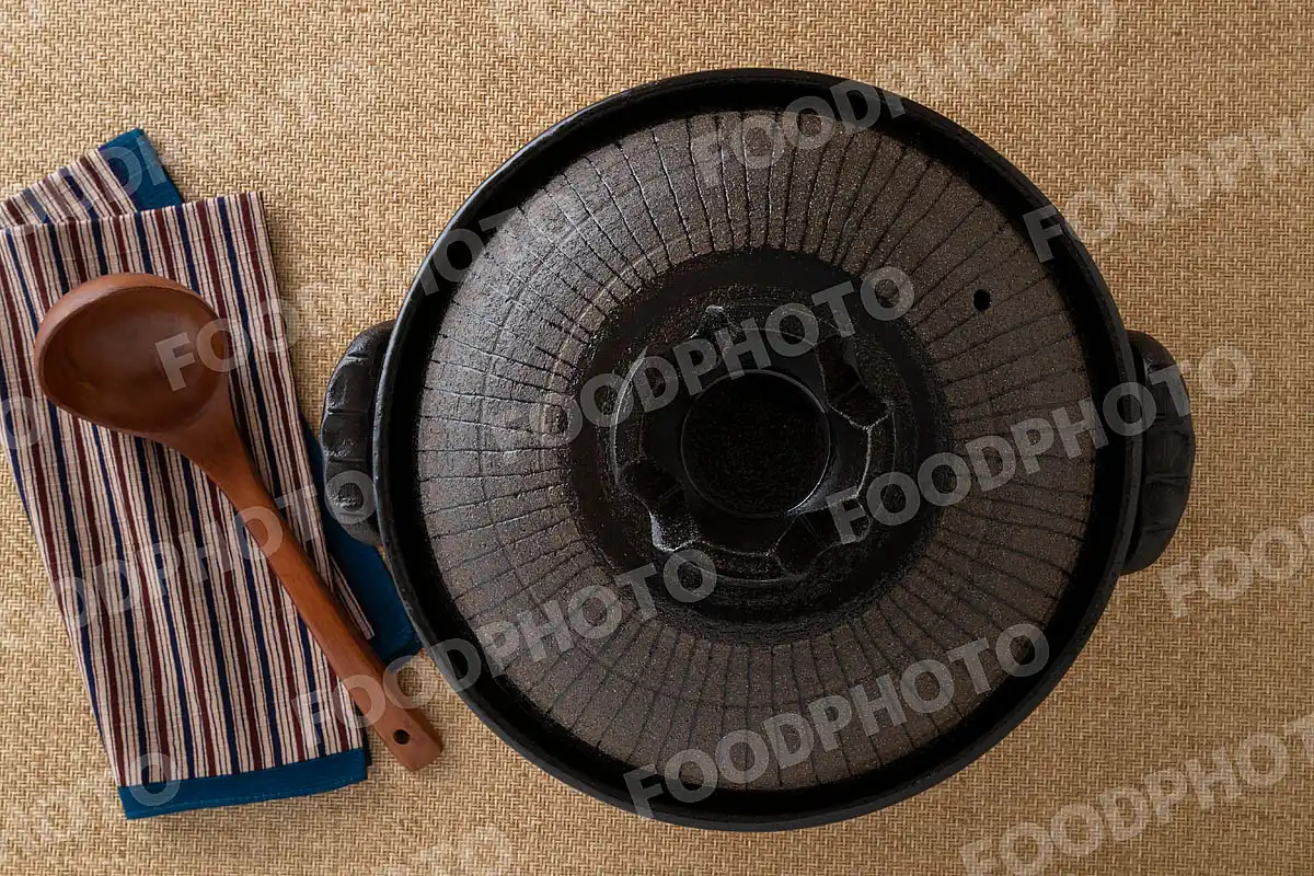 木製のおたまとずっしりと力強い大きな黒い土鍋 / 蓋閉