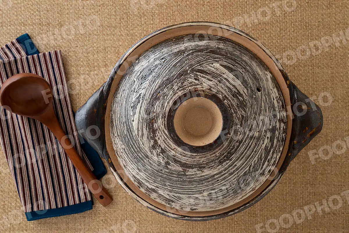 木製のおたまと荒々しい模様の大きな土鍋 / 蓋閉