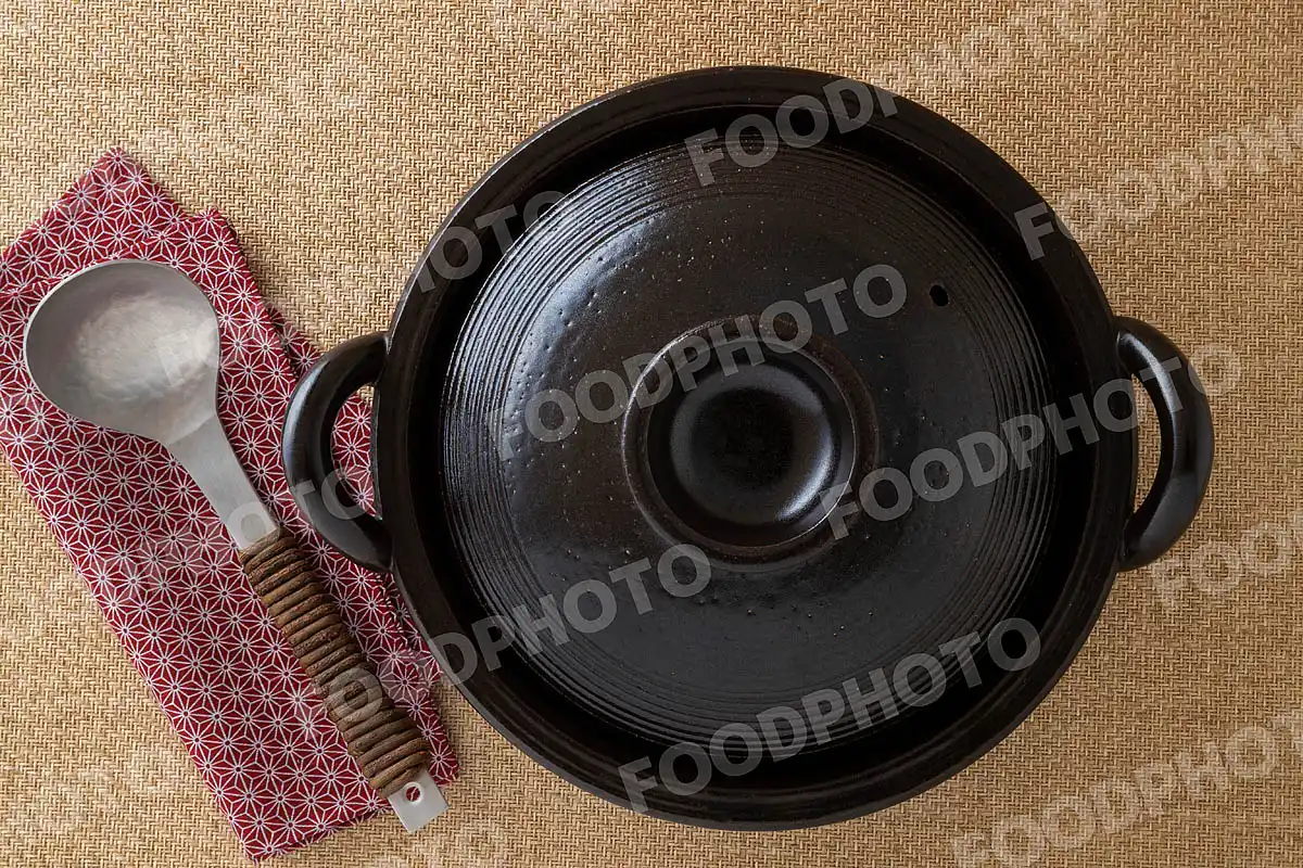 アルミのおたまと光沢感あるシンプルなデザインの黒い土鍋 / 蓋閉