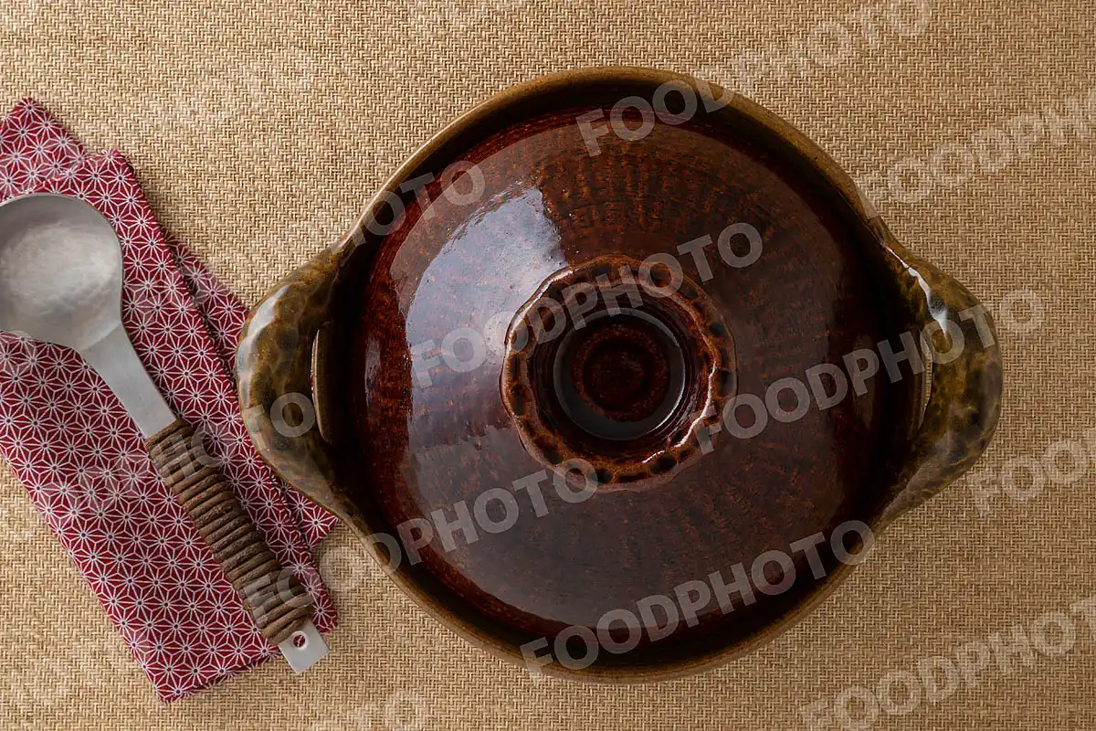 アルミのおたまと肉厚で大きな取手が雰特徴的な鶯色の土鍋 / 蓋開