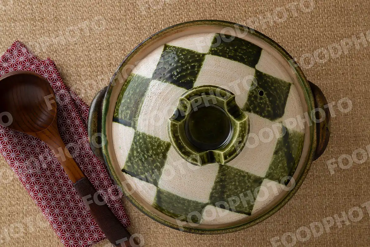 木製のおたまと白と深緑の市松模様がきれいな土鍋 / 蓋開