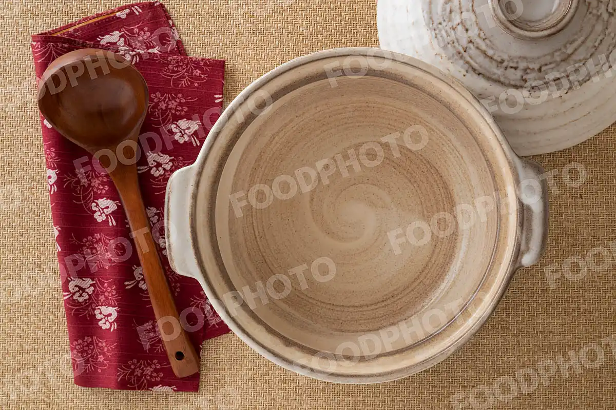 木製のおたまと灰色の素朴な土鍋 / 蓋開