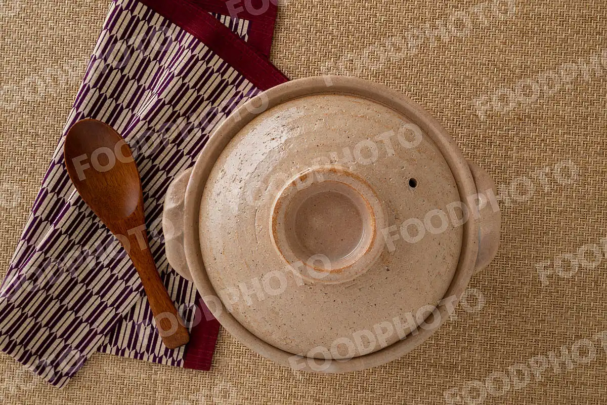 木製のレンゲとお手拭き。素朴な雰囲気の小さな土鍋 / 蓋閉