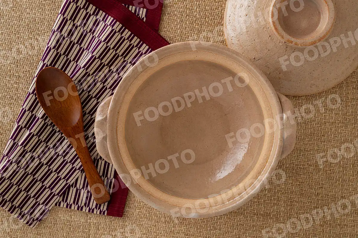 木製のレンゲとお手拭き。素朴な雰囲気の小さな土鍋 / 蓋開