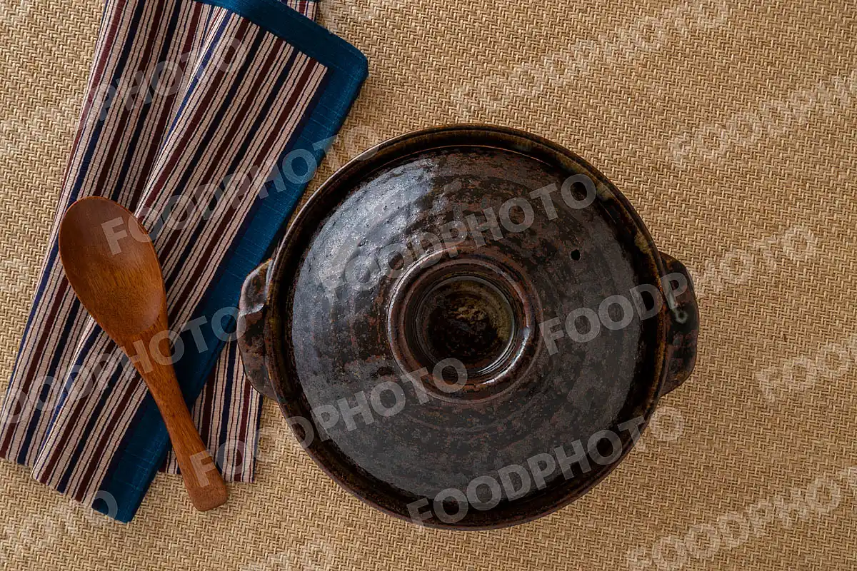 木製のレンゲとお手拭き。素朴な雰囲気の小さな土鍋 / 蓋閉