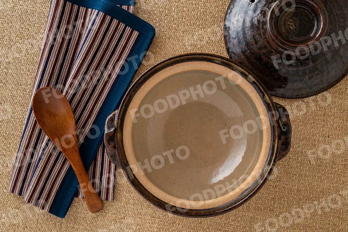 木製のレンゲとお手拭き。素朴な雰囲気の小さな土鍋 / 蓋開