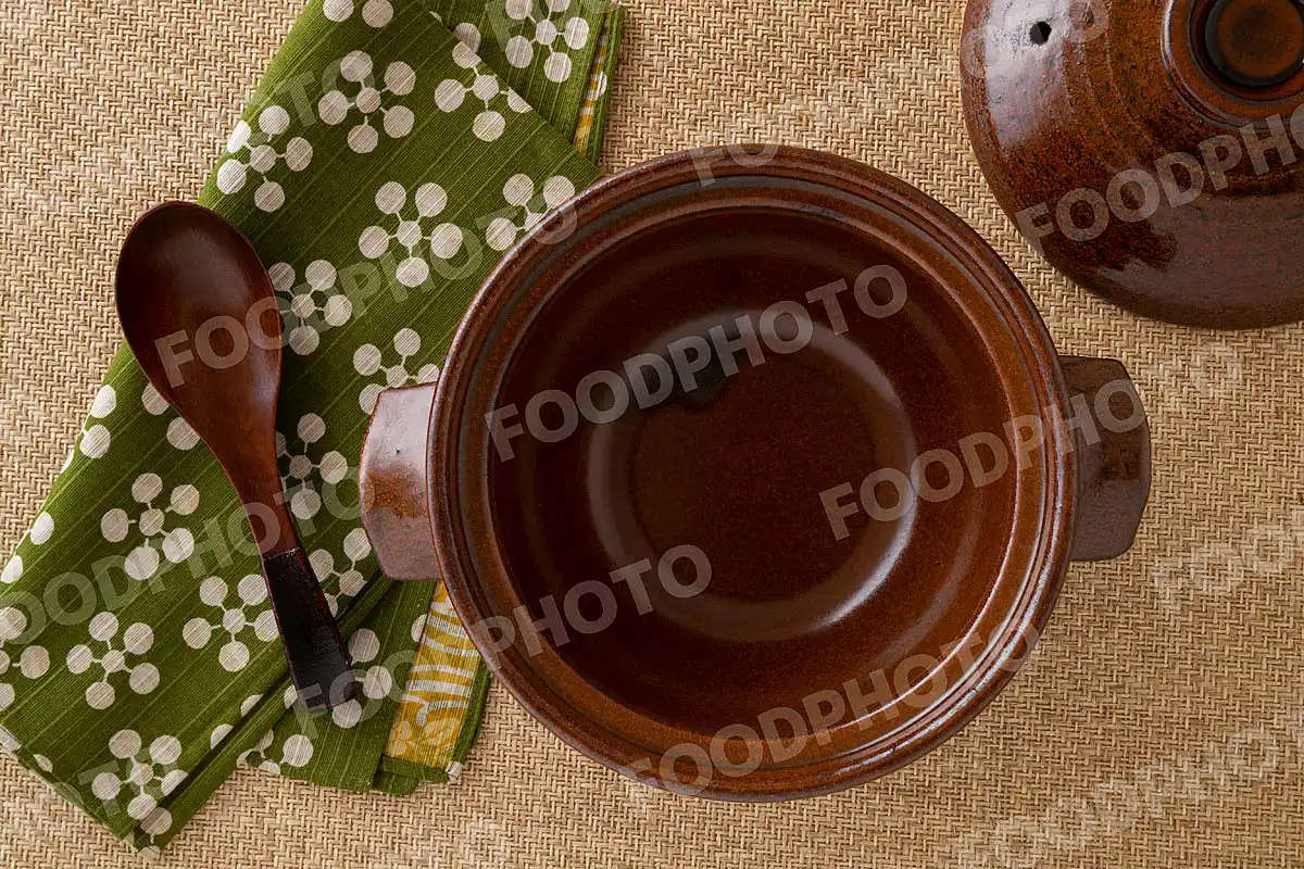 木製のレンゲと花柄のお手拭き。素朴な雰囲気の小さな飴色の土鍋 / 蓋開